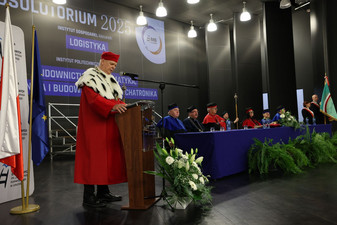 Rektor przemawiający przy mównicy. W tle slajd z tytułem absolutorium 2025.