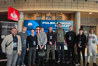 Grupa dziewięciu mężczyzn z identyfikatorami na szyi.